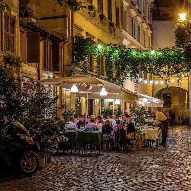 Trastevere di sera, vicoli e tavoli all’aperto