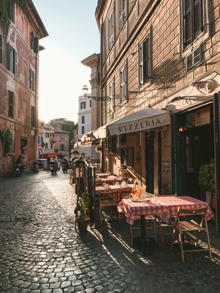 Tavoli all’aperto su una strada acciottolata di Trastevere